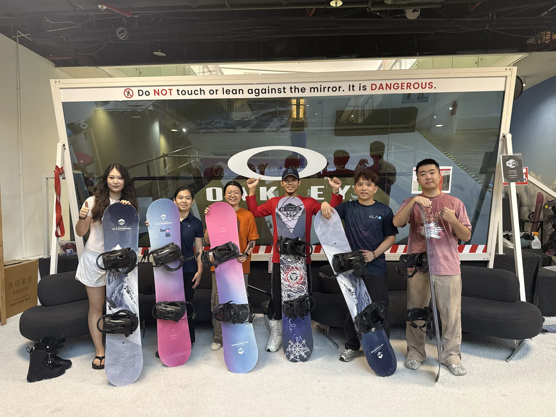 Members posing together with snowboards after an indoor weekly training session