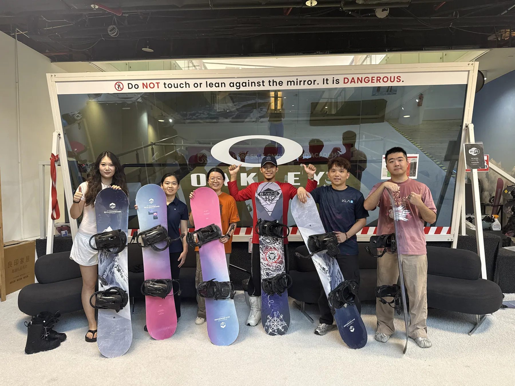 Members holding snowboards together after an indoor training session