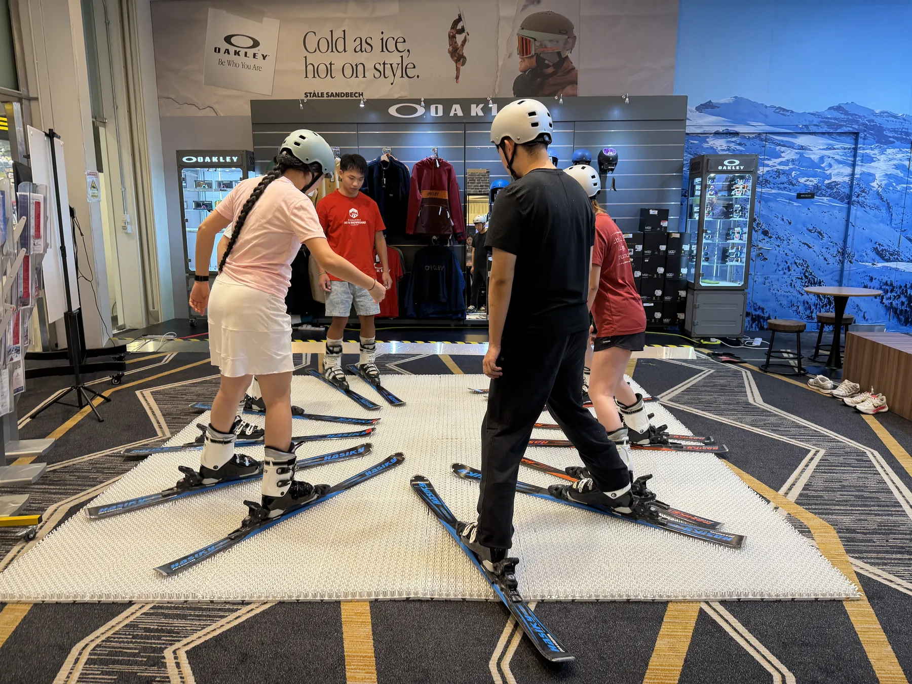Participants practising ski technique with an instructor on an indoor training surface
